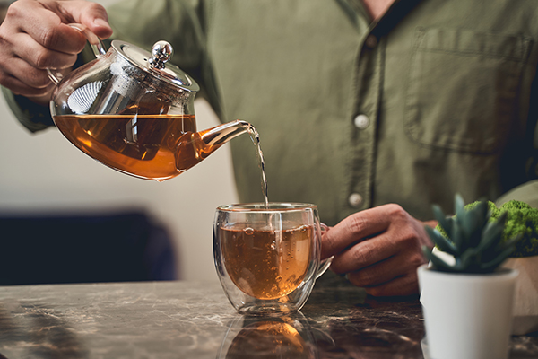 Man pouring tea from tea infuser